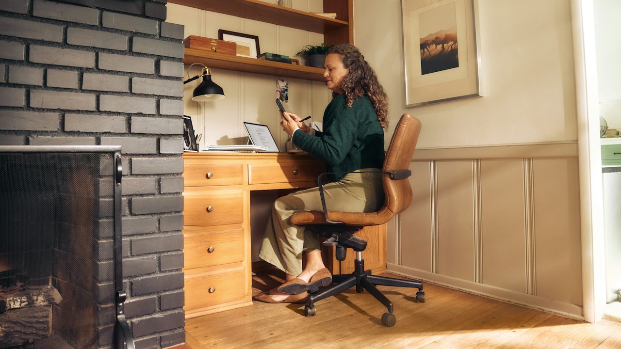 A woman working at a desk in a cozy home office